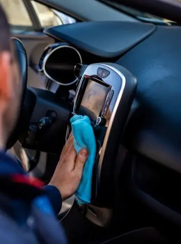 Wiping down the interior of a car involves using a soft cloth or microfiber towel to remove dust, dirt, and debris from various surfaces inside the vehicle. The detailer typically starts from the dashboard and works their way down to the center console, door panels, seats, and other interior components. They may also use a gentle cleaning solution or interior detailer spray to effectively lift and remove any stubborn stains or grime. This process helps to maintain a clean and tidy interior, enhancing the overall appearance and comfort of the vehicle.